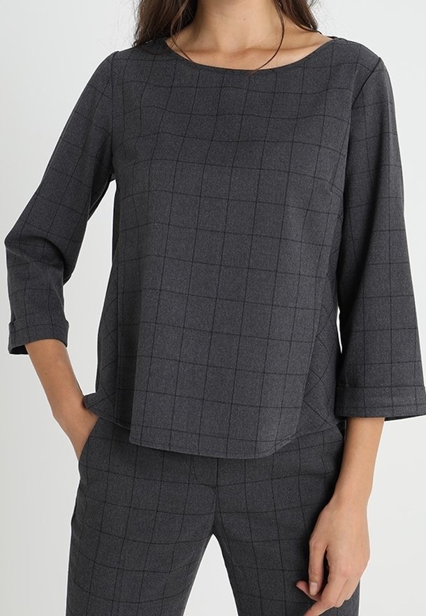 Blusa grigia a quadri con scollatura a barca e maniche a tre quarti, realizzata in un tessuto strutturato, caratterizzata da un motivo a quadri.