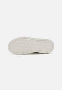 Talpa de pantof din cauciuc alb, cu un model de grilă texturată și margini zimțate pentru aderență. Plat, cu un contur subtil la călcâi.