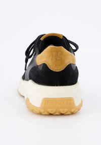 Zwarte suède en mesh sneaker met een tan suède accent bij de hiel, voorzien van een witte tussenzool en een gestructureerde gumrubberen loopzool.