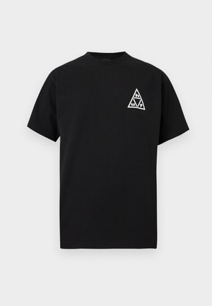 T-shirt noir à manches courtes avec un petit logo triangulaire blanc sur la poitrine gauche, présentant des lettres et des symboles stylisés.