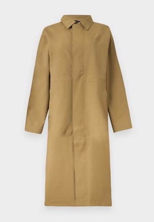 Lang beige trenchcoat med enkeltstående knapper, krave, lange ærmer og skjulte knapper foran, vist på en ensfarvet baggrund.