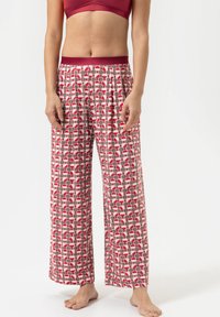 Un pantalon de pyjama rouge et gris présente un motif circulaire répété, avec une taille élastique et une coupe ample, fabriqué dans un tissu doux.