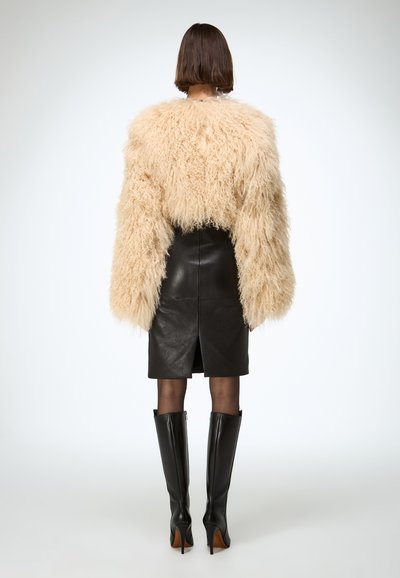 Fluffy beige faux fur jacket, black leather pencil skirt, paired with knee-high black heeled boots. Clean, minimalist background.