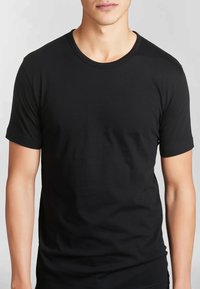 T-shirt nera a maniche corte in cotone, con colletto alla marinara e una texture liscia, aderente al corpo senza dettagli di design aggiuntivi.