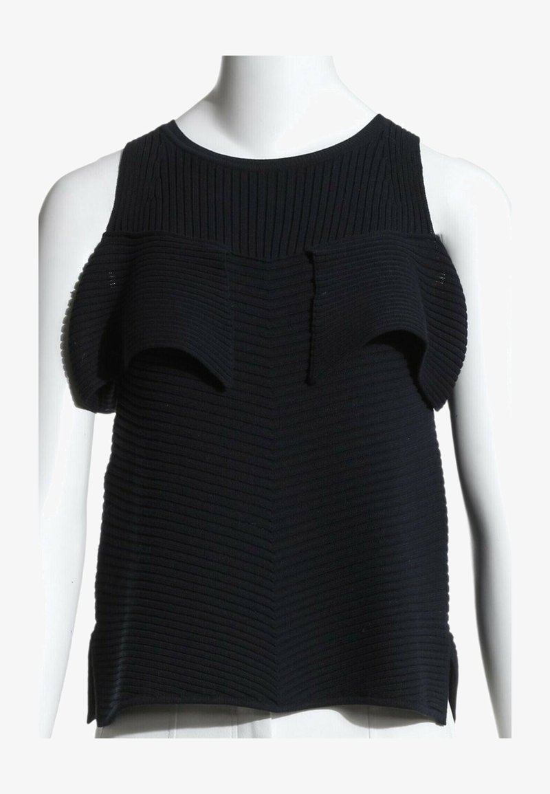 Haut sans manches noir côtelé avec des détails de tissu relevés et pliés autour des emmanchures sur un torse de mannequin blanc.