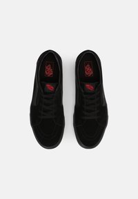Sneaker in suede nero con design con lacci, caratterizzati da un marchio rosso sulla soletta e sul lato, e una suola testurizzata.