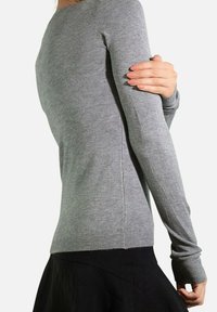 Pull à manches longues gris fabriqué en tricot doux ; design ajusté avec des poignets et un ourlet côtelés, accentué par une texture lisse.
