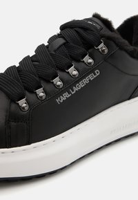 Juodos odinės sportinės kedai su storomis juodomis raištelėmis, metaliniais akytėmis, pūkų pamušalu, baltu padu ir Karl Lagerfeld ženklu šone ir padu.