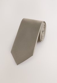 Beige Krawatte mit strukturierter Musterung und spitzer Spitze, aufgerollt zur Präsentation. Hergestellt aus einem Stoff mit einer weichen, glatten Oberfläche.