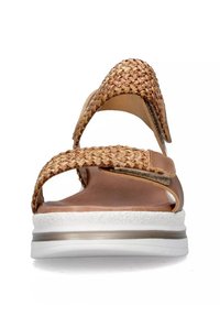 Sandali superiori intrecciati marroni con fasce larghe, soletta imbottita e una suola bianca spessa con un accento metallico.