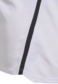 T-shirt de sport blanc avec une finition texturée, comportant des accents de rayures noires sur les côtés et un ourlet cousu. Conçu pour les activités sportives.