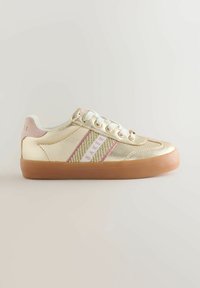 Kuldsed metallilised madalad tossud valgete sidekottidega, roosa ja kuldne triibuline külgtäht ning kummitald neutraalsel taustal.