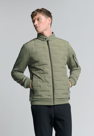 Gevoerde olijfgroene jas met een hoge kraag, ritssluiting aan de voorkant en een gestructureerd lichaam. Voorzien van zij- en armzakken met rits en ribgebreide manchetten.