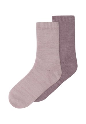 Deux chaussettes tricotées unies de longueur moyenne, l'une mauve clair et l'autre mauve plus foncé, posées en chevauchement sur un fond blanc.