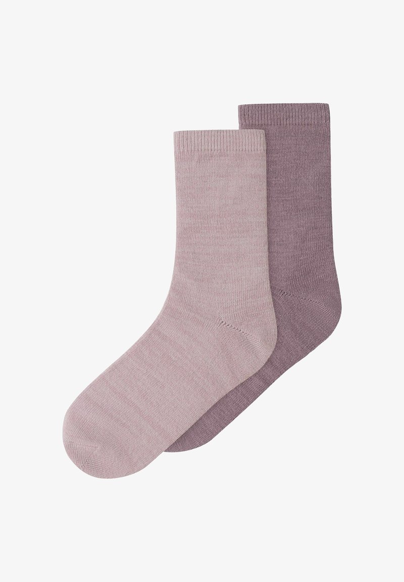 Deux chaussettes tricotées unies de longueur moyenne, l'une mauve clair et l'autre mauve plus foncé, posées en chevauchement sur un fond blanc.