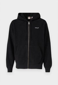 Svart fleece zip-up hoodie med hel dragkedja, kängurufickor och en liten vit Levi's-logotyp på vänster bröst.