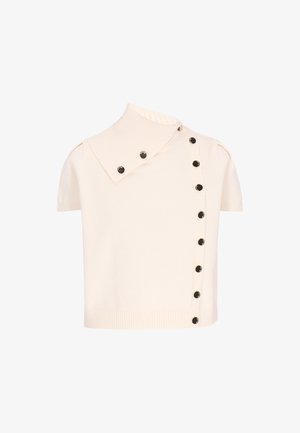 Haut en tricot crème à manches courtes avec un large col côtelé et deux rangées de boutons noirs, l'une verticale et l'autre inclinée sur le col.