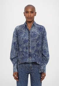 Denimskjorte med blomstertrykk i blå nyanser, med krage, knappestolpe foran og løse, lange ermer.