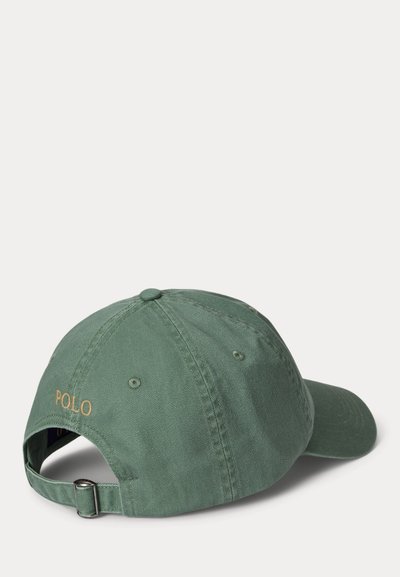 Grønn bomull baseballcap med buet brem, justerbar stropp og "POLO" brodert i gull på baksiden. Silkeaktig tekstur og uformell design.