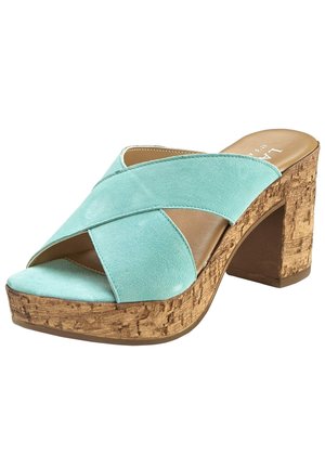 Aqua suede high-heeled sandal with crossed straps and cork platform. The heel is block-shaped, offering stability and support.
