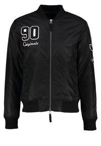 Blouson aviateur noir avec fermeture éclair à l'avant, col, poignets et ourlet côtelés, texte blanc "90 Originals" sur le côté gauche de la poitrine et détails en patch sur la manche gauche.