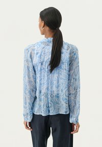 Blusa azzurro chiaro con maniche lunghe, motivo paisley e collo alto. Realizzata in tessuto trasparente con una vestibilità comoda e dettaglio arricciato sul retro.