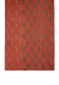 Materiał w kolorze rdzy z wzorem paisley w zieleni i złocie, z ozdobnymi detalami. Krawędzie są postrzępione, co dodaje tekstury projektowi.