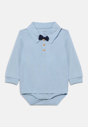 Body pour bébé à manches longues de couleur bleu clair avec col, trois boutons en bois et nœud papillon bleu marine attaché au niveau du col.