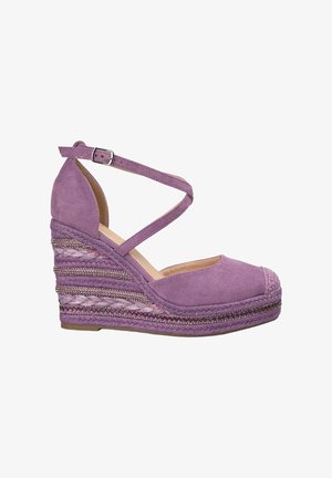 Sandales compensées en suede violet avec une bride cheville entrecroisée, des détails tressés et une plateforme style espadrille texturée.