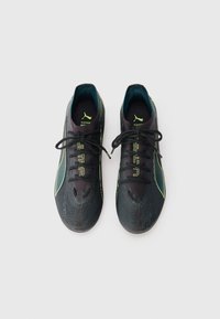 Black athletic shoes with lime green accents and textured upper, featuring a lace-up design and a streamlined silhouette.