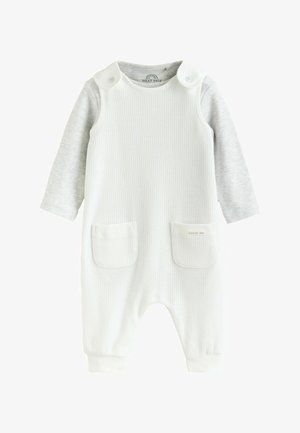 Witte geribbelde baby romper met lange grijze mouwen, twee zakken aan de voorkant en drukknoopsluitingen op de schouders.
