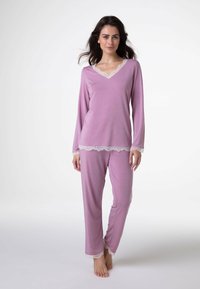 Set di pigiama rosa composto da una maglia a maniche lunghe con scollo a V e rifiniture in pizzo, abbinata a pantaloni coordinati con dettagli in pizzo al fondo.