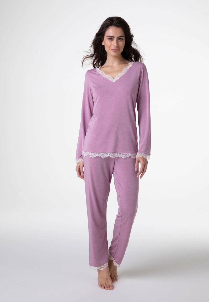 Set di pigiama rosa composto da una maglia a maniche lunghe con scollo a V e rifiniture in pizzo, abbinata a pantaloni coordinati con dettagli in pizzo al fondo.