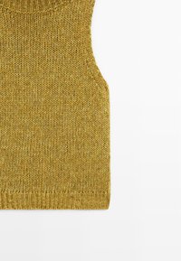 Top smanicato di colore giallo senape in maglia, con scollatura rotonda, tessuto testurizzato e orlo a coste aderente.