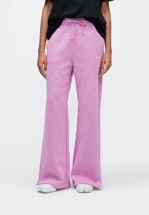 Růžové široké tepláky z měkké tkaniny, s elastickým pasem se stahovací šňůrkou a malým bílým logem na levé straně.