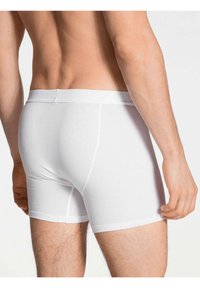 I boxer briefs bianchi in cotone presentano una vestibilità aderente con una texture liscia, una vita elastica e dettagli di cucitura sottili.