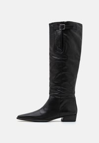 Bottes en cuir noir, hauteur genou, avec un bout pointu, un talon plat et des détails de boucle sur le côté ; texture lisse et design élégant.