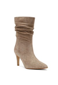 Stivale alla caviglia in suede beige con punta affilata, upper morbido e tacco alto e sottile. Texture liscia e design minimalista.