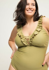 Maillot de bain une pièce vert olive avec un col froncé et un détail croisé au niveau de la poitrine. Tissu doux, forme ajustée et couverture modeste.