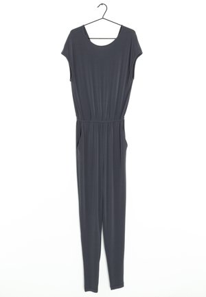 Mono de jersey gris con mangas cortas, escote en forma de barco, cintura elástica, bolsillos laterales y piernas ajustadas. Cuelga de una percha negra.