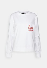 Vit sweatshirt i bomullsblandning, med långa ärmar och rund halsringning. Framficka till vänster med röd broderad text "love moschino."