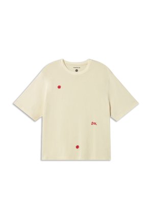 Crèmekleurig T-shirt met korte mouwen en rode geborduurde accenten, waaronder bloemen en het woord "SOL." Zacht materiaal, ontspannen pasvorm, ronde hals.