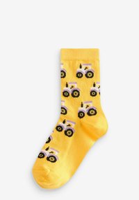 Gula strumpor med ett mönster av små traktorer i lila och svart. Tillverkade av ett mjukt, texturerat tyg med ribbade muddar.