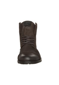 Bottes basses en cuir marron avec un bout arrondi, une semelle plate, un laçage à l'avant et des coutures décoratives. Comprend une languette texturée au col.