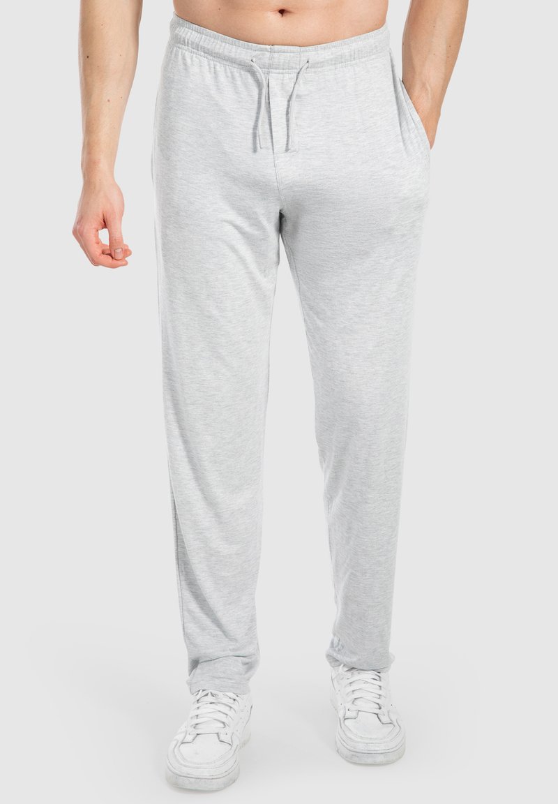 Hellgraue Jogginghosen aus einem weichen Baumwollmix, mit einem elastischen Bund mit Kordelzug, Seitentaschen und einer lockeren Passform.