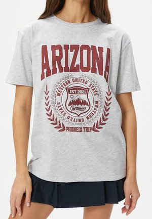 Kobieta w szarej koszulce z bordowym napisem "ARIZONA" i "Western United State Phoenix Trip" oraz grafiką góry na środku.