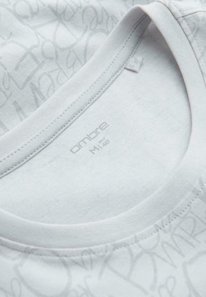 Hvid bomulds T-shirt med rund halsudskæring, prydet med lysegrå tekstmønstre og med teksten "ombre M 48" indeni kraven.