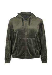 Giacca a zip verde oliva in morbido tessuto vellutato con cappuccio. Presenta due tasche frontali e polsini a costine per una vestibilità aderente.