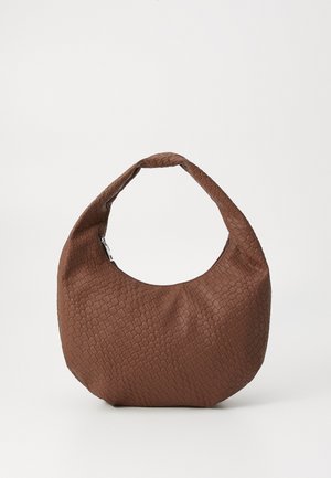 Prune kudumine kott ümmarguse kujuga, millel on üks pehme käepide ja tekstureeritud pind. Nähtavad on ainult õmblused, ilma igasuguste metallosade või aksessuaarideta.