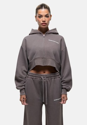 Geknipte grijze hoodie met een rits, oversized mouwen en geborduurde tekst. Gecombineerd met bijpassende grijze sweatpants met een elastische tailleband.